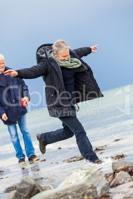 happy elderly senior couple walking on beach