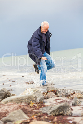 happy elderly senior couple walking on beach