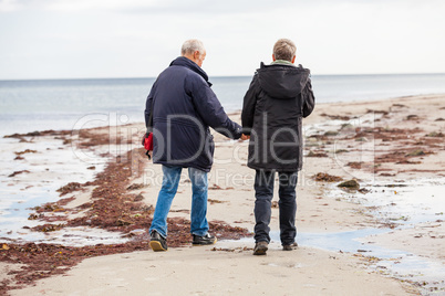 happy elderly senior couple walking on beach