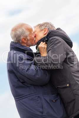 happy elderly senior couple walking on beach