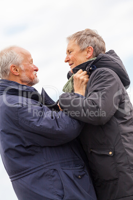 happy elderly senior couple walking on beach