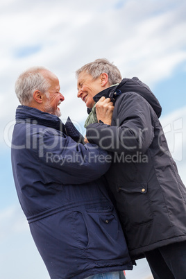 happy elderly senior couple walking on beach