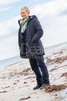 happy elderly senior couple walking on beach