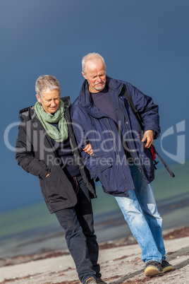 happy elderly senior couple walking on beach