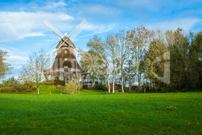 Traditional wooden windmill in a lush garden