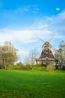 Traditional wooden windmill in a lush garden