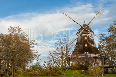 Traditional wooden windmill in a lush garden