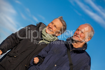 happy elderly senior couple walking on beach