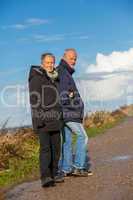happy elderly senior couple walking on beach