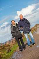 happy elderly senior couple walking on beach