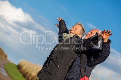 Elderly couple embracing and celebrating the sun