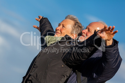 Elderly couple embracing and celebrating the sun