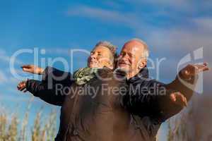 Elderly couple embracing and celebrating the sun