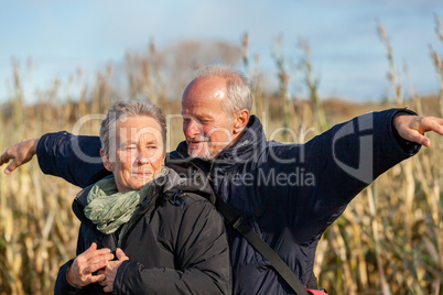 Elderly couple embracing and celebrating the sun