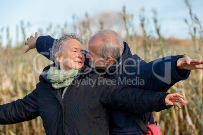 Elderly couple embracing and celebrating the sun