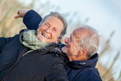 Elderly couple embracing and celebrating the sun