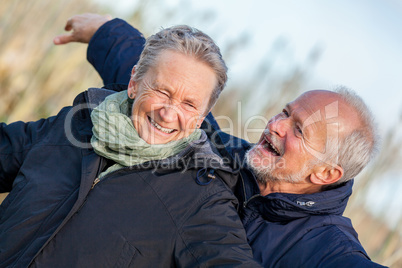 Elderly couple embracing and celebrating the sun