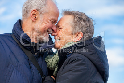 Elderly couple embracing and celebrating the sun