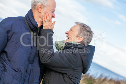 Elderly couple embracing and celebrating the sun