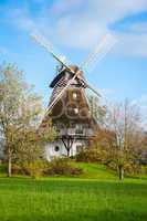 Traditional wooden windmill in a lush garden