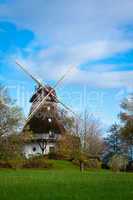 Traditional wooden windmill in a lush garden