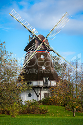 Traditional wooden windmill in a lush garden