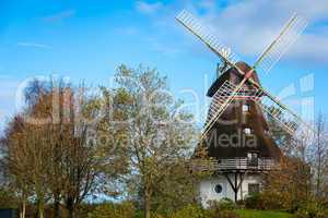 Traditional wooden windmill in a lush garden