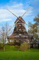 Traditional wooden windmill in a lush garden