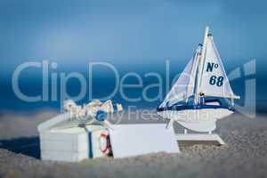 sailing boat and seashell in sand decoration closeup