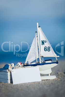 sailing boat and seashell in sand decoration closeup