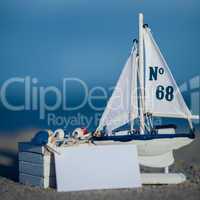 sailing boat and seashell in sand decoration closeup