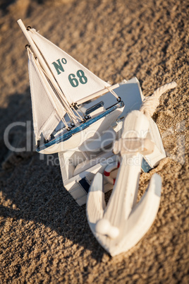 sailing boat and seashell in sand decoration closeup