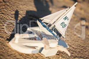 sailing boat and seashell in sand decoration closeup