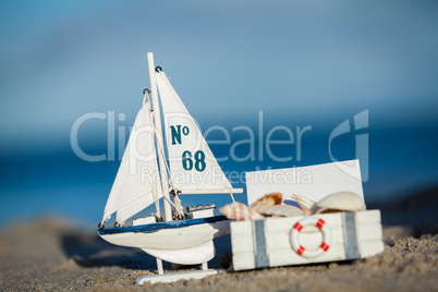 sailing boat and seashell in sand decoration closeup