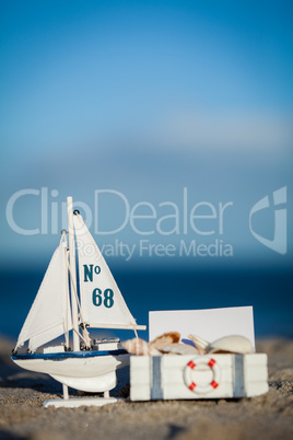 sailing boat and seashell in sand decoration closeup