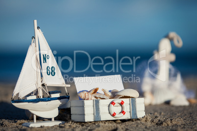 sailing boat and seashell in sand decoration closeup