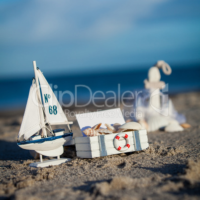 sailing boat and seashell in sand decoration closeup