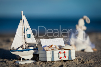 sailing boat and seashell in sand decoration closeup