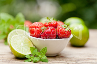 fresh tasty sweet strawberries and green lime outdoor in summer