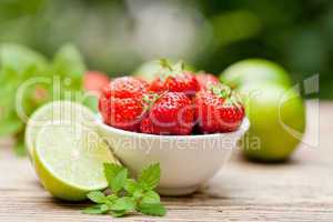 fresh tasty sweet strawberries and green lime outdoor in summer