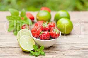 fresh tasty sweet strawberries and green lime outdoor in summer