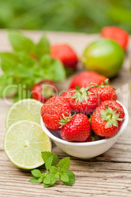 fresh tasty sweet strawberries and green lime outdoor in summer