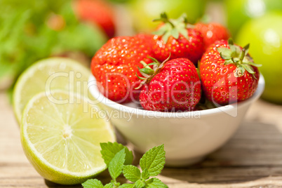 fresh tasty sweet strawberries and green lime outdoor in summer