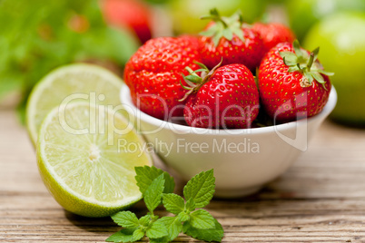 fresh tasty sweet strawberries and green lime outdoor in summer