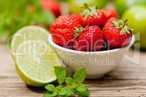 fresh tasty sweet strawberries and green lime outdoor in summer