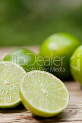 green fresh lime on wooden table macro closeup outdoor