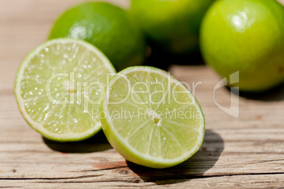 green fresh lime on wooden table macro closeup outdoor