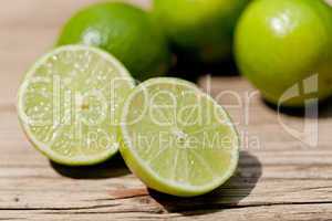 green fresh lime on wooden table macro closeup outdoor