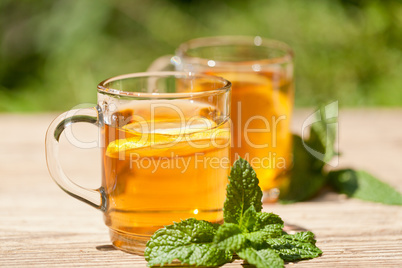 fresh tasty hot tea lemon and mint outdoor in summer