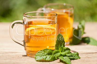 fresh tasty hot tea lemon and mint outdoor in summer